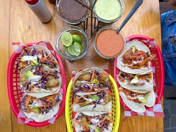 A table with plates full of colorful seafood tacos in Puerto Vallarta, Mexico